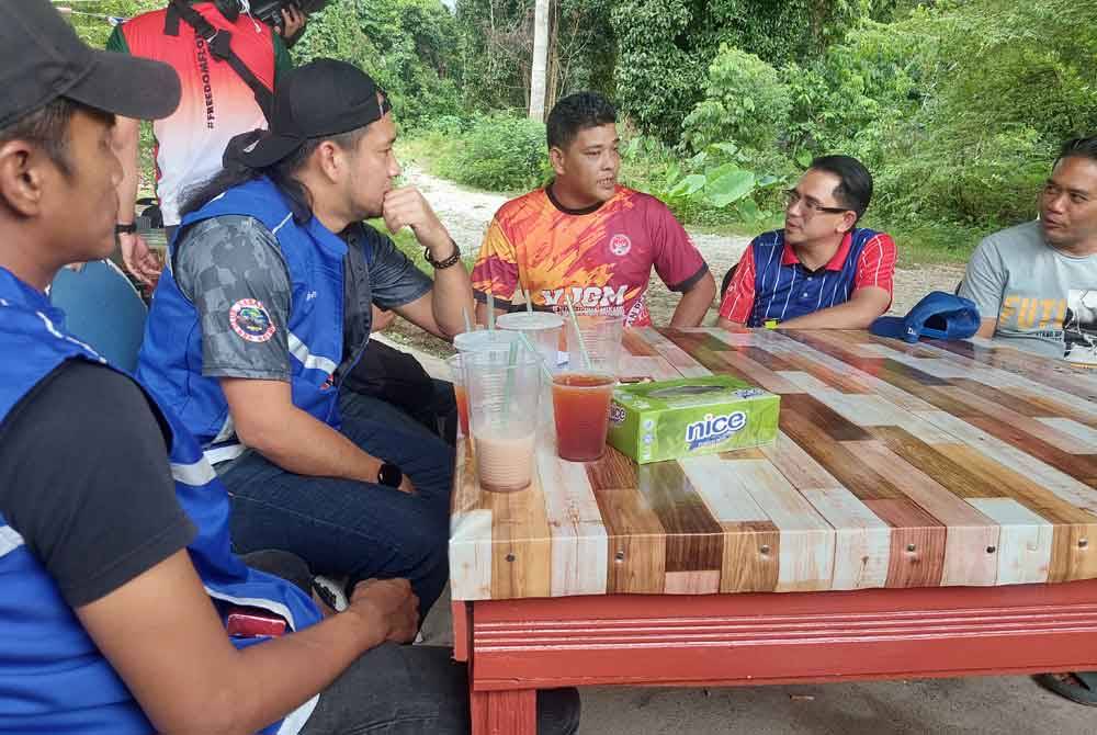 Mohd Azmawi (dua dari kanan) berbual bersama golongan muda ketika turun berkempen di Kampung Bertam Lama, Gua Musang pada Ahad.