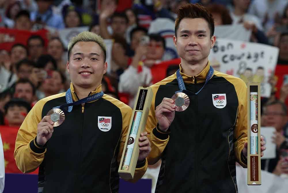 Beregu lelaki badminton negara, Aaron Chia dan Soh Wooi Yik menunjukkan pingat gangsa pada majlis penyampaian pingat dalam acara badminton pada Sukan Olimpik Paris 2024 di Arena Porte De La Chapelle pada Ahad. Foto Bernama