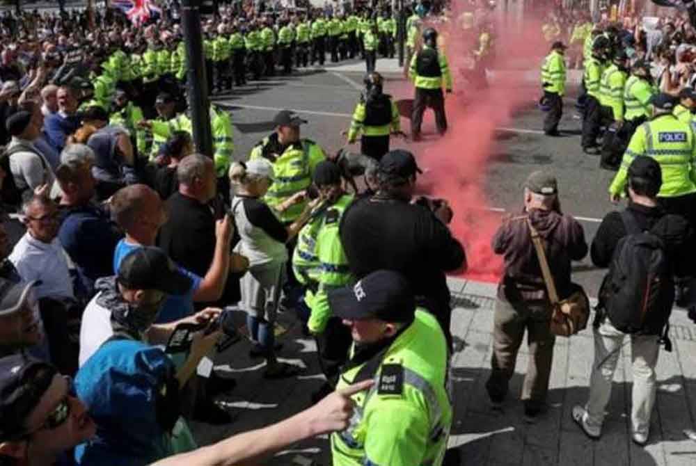 Pasukan polis United Kingdom mengawal keselamatan ketika sekumpulan penunjuk perasaan melakukan protes menentang pendatang haram di Liverpool, Britain. - Foto Reuters