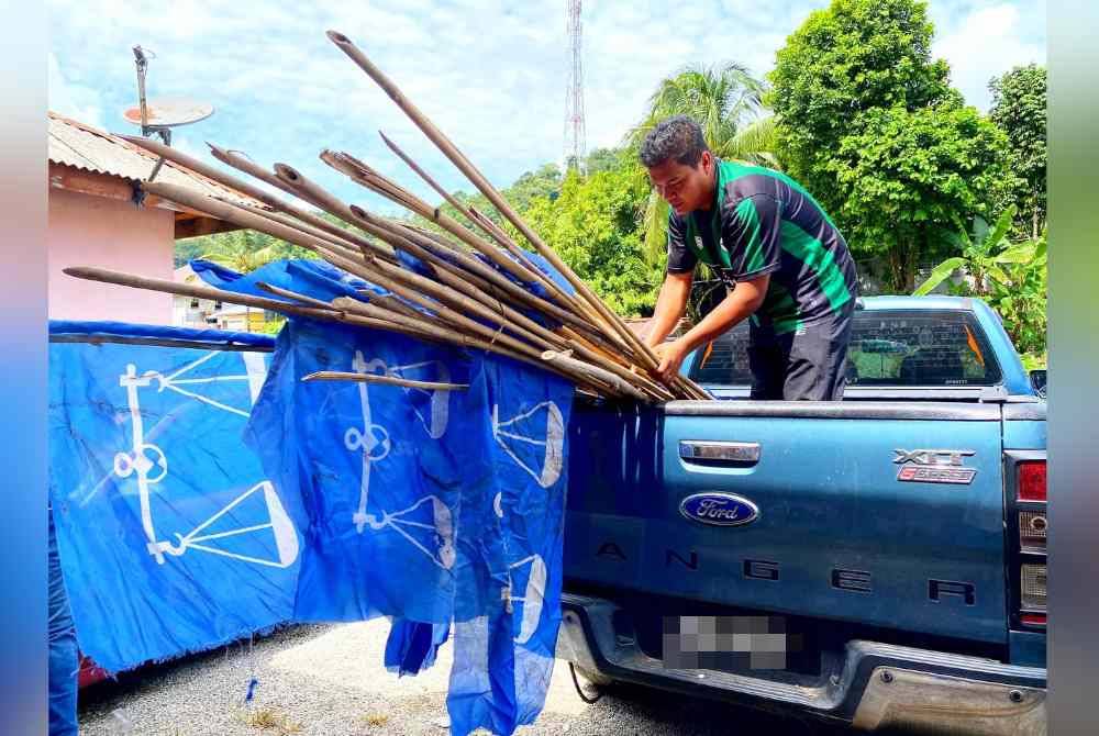 Raja Mohd Iskandar sedang bersiap sedia untuk keluar memasang bendera di sekitar Ladang Sungai Terah.