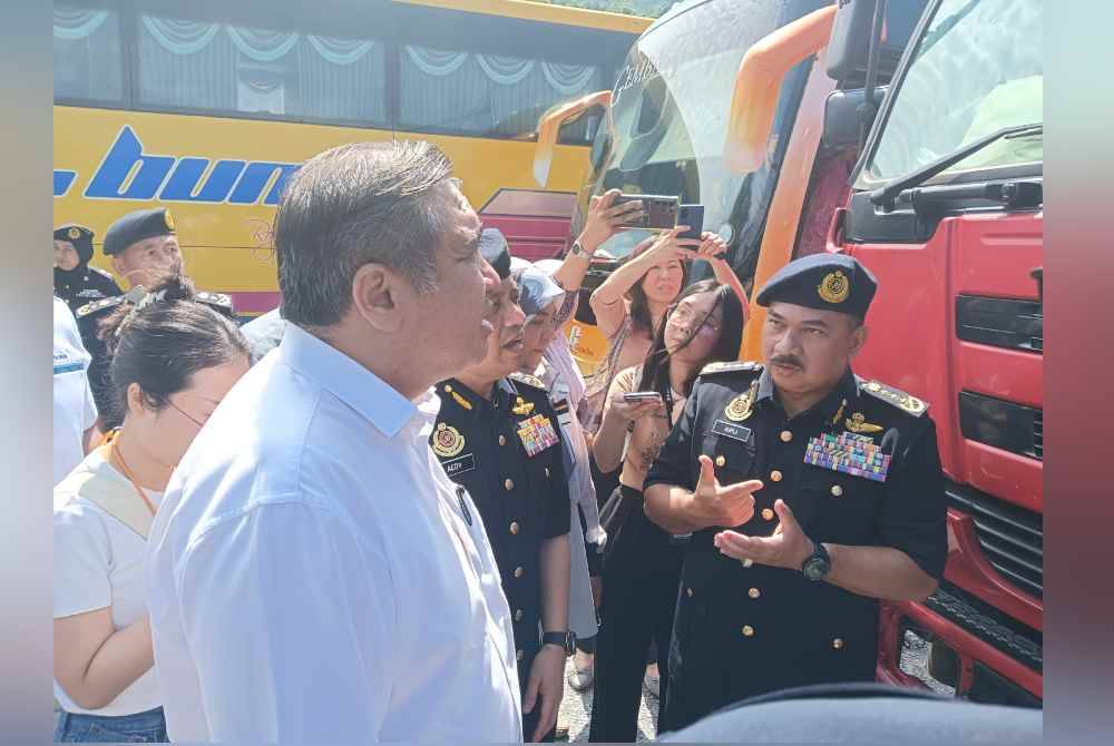 Anthony Loke (kiri) mendengar penerangan daripada Muhammad Kifli (kanan) berhubung operasi khas bersepadu kenderaan pelancongan, perkhidmatan awam dan perdagangan di Stesen Penguatkuasaan Jabatan Pengangkutan Jalan (JPJ) Gombak, Selangor pada Selasa. Foto HISYAMUDDIN AYUB.