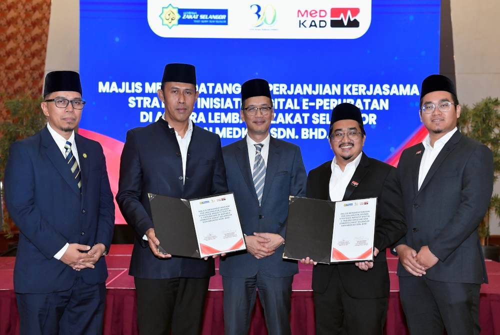 Dr Tunku Muzafar Shah (tengah) bergambar bersama Mohd Sabirin (dua dari kiri) dan Ezuan (dua dari kanan) selepas Majlis Menandatangani Perjanjian Kerjasama Strategik Inisiatif Digital E-Perubatan. Foto Bernama