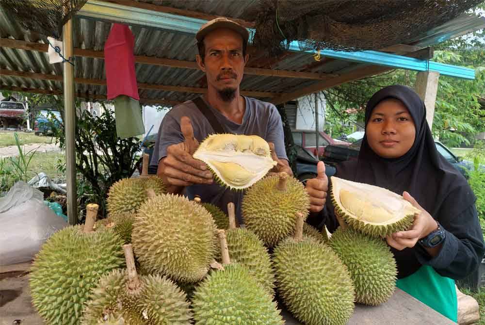 Kamil dan Nur Syakila menunjukkan durian yang di jual di gerai mereka di Kampung Kala, Nenggiri, Gua Musang pada Rabu.