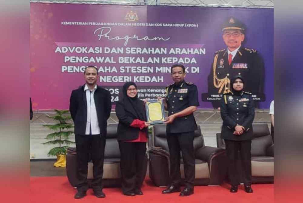 Azman (dua dari kanan) menyerahkan surat arahan pegawai bekalan kepada wakil pemilik stesen minyak pada Program Advokasi dan Serahan Arahan Pengawal Bekalan kepada Pengusaha Stesen Minyak di Kedah di Dewan Kenangan Majlis Perbandaran Sungai Petani, di sini, pada Rabu.