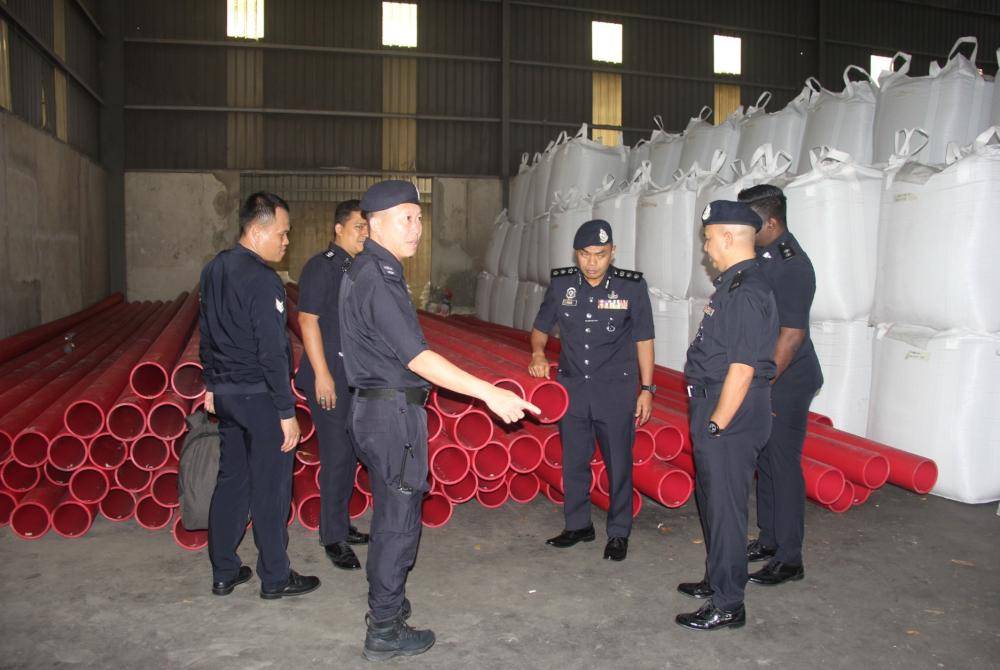 Raub (tiga dari kanan) memeriksa batang paip saluran kabel elektrik yang dicuri dan disimpan di sebuah premis di Kawasan Perindustrian Indahpura, Kulai. Foto PDRM