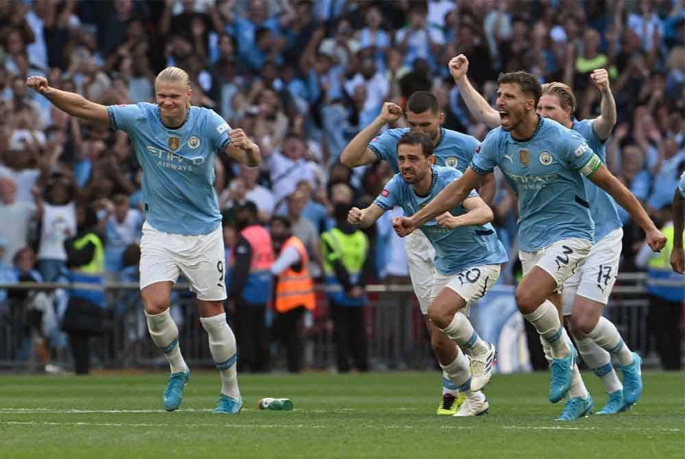 Pemain pertahanan Manchester City, Ruben Dias (kanan) dan pemain tengah Bernardo Silva (tengah) meraikan jaringan Manuel Akanji yang meledak gol kemenangan City ketika menewaskan United dalam aksi Perisai Komuniti di Stadium Wembley. Foto AFP