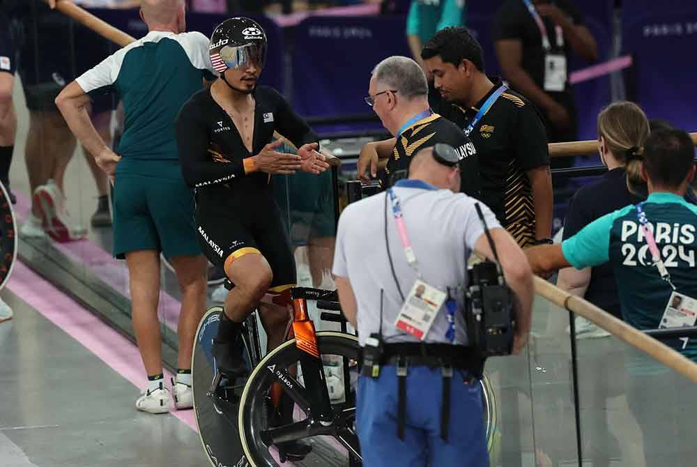 Azizulhasni (dua dari kiri) memperkatakan sesuatu kepada Beasley. Foto Bernama