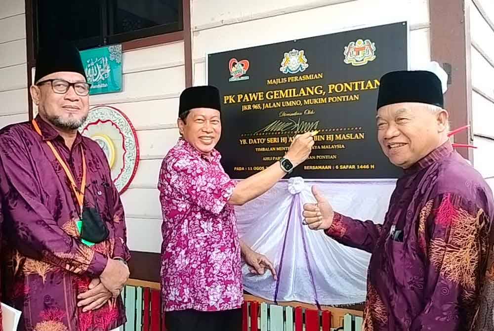 Ahmad ( tiga dari kiri) menandatangani plak perasmian Pusat Aktiviti Warga Emas (PAWE) Pontian pada Ahad.