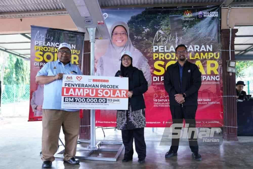 Aiman Athirah (dua dari kanan) menerima replika penyerahan projek lampu solar daripada Pegawai Daerah dan Tanah Sepang, Khairi Azali Ibrahim di Parlimen Sepang pada Ahad. - FOTO: SINAR HARIAN / MOHD HALIM ABDUL WAHID