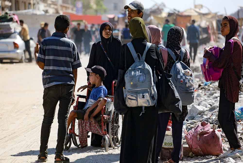 Seorang kanak-kanak Palestin kurang upaya duduk di atas kerusi roda ketika orang ramai meninggalkan daerah kediaman Hamad dan sekitarnya di Khan Yunis di selatan Semenanjung Gaza selepas menerima amaran daripada tentera Israel untuk mengosongkan kawasan itu. Foto AFP