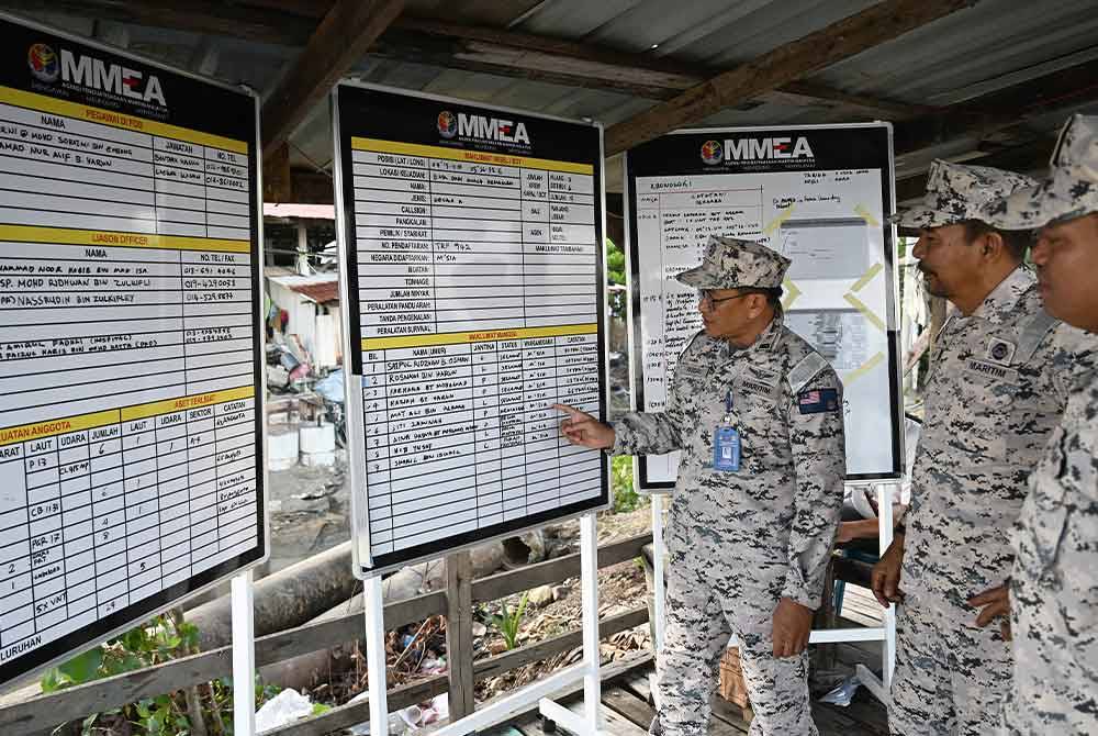 Anggota Maritim Malaysia melihat maklumat mengenai mangsa yang hilang dalam kejadian bot nelayan dan tongkang berlanggar di perairan Kemaman di Jeti Haji Pa Kuala Kemaman hari ini. Foto Bernama