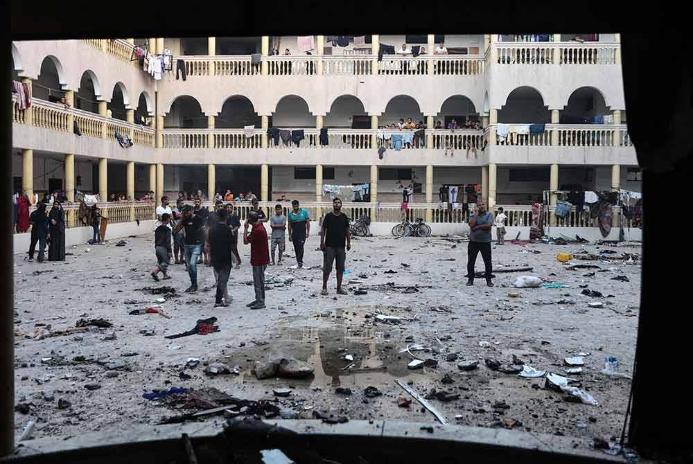 Warga Palestin berkumpul di kawasan sekolah selepas dibom tentera Israel pada Sabtu. Foto AFP