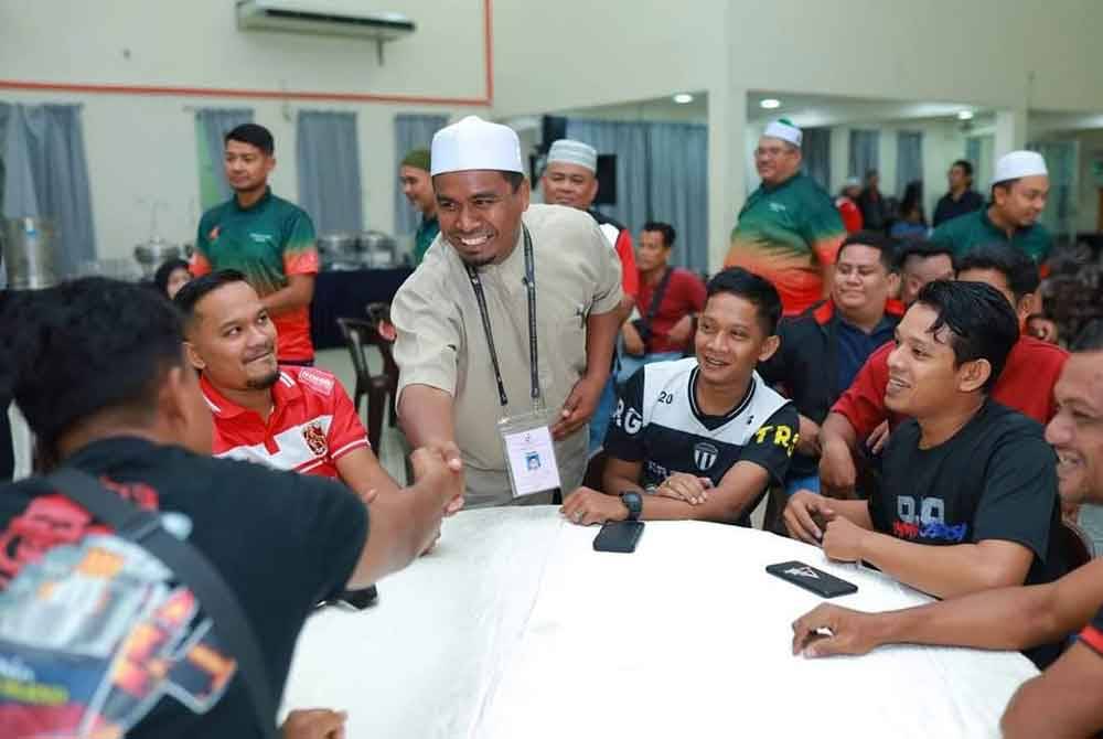 Mohd Rizwadi (berdiri) bersalaman dengan pengundi luar yang ditemui di Kuala Lumpur pada Ahad.