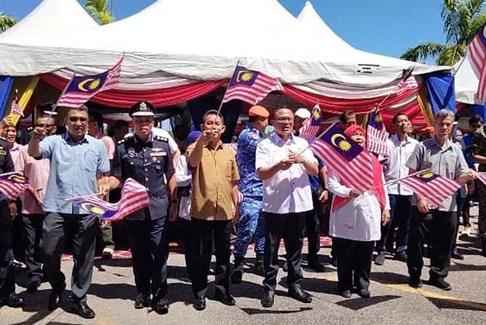 Naim Fahmi (tiga dari kanan) bersama tetamu jemputan mengibarkan bendera pada Majlis Pelancaran Bulan Kebangsaan Dan Kibar Jalur Gemilang 2024 Peringkat Negeri Kelantan pada Isnin.