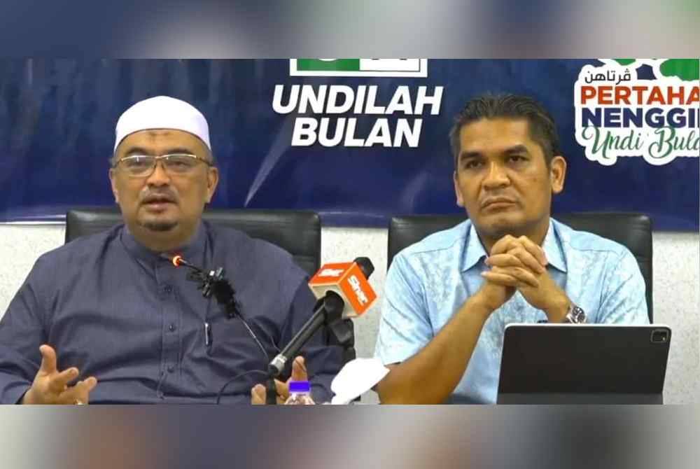 Mohamed Fadzli (kiri) pada sidang akhbar di Pusat Informasi PN PRK Nenggiri, Gua Musang pada Isnin.