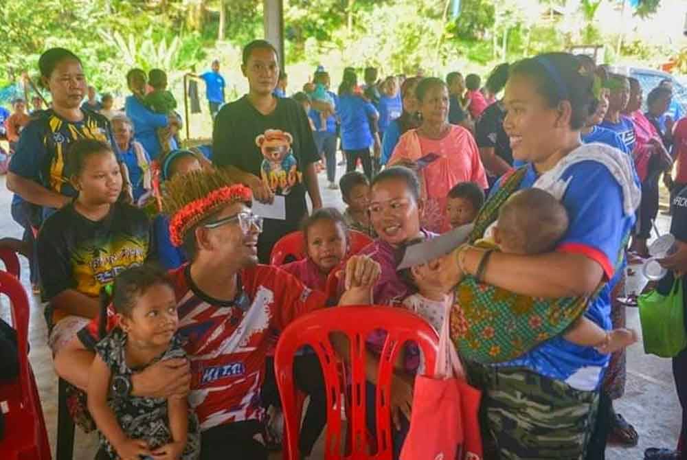 Awie (kiri) beramah mesra dengan masyarakat Orang Asli di Pos Pasik, Gua Musang semasa turun berkempen di sana.