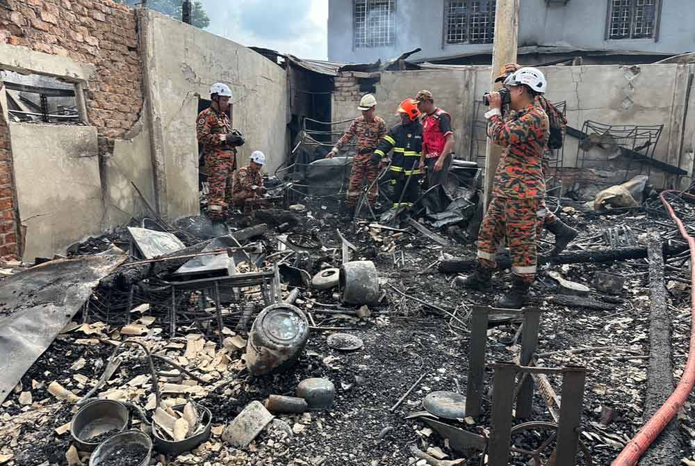 Anggota bomba menjalankan siasatan di lokasi kebakaran sebuah rumah pada Rabu. - Foto Sinar Harian