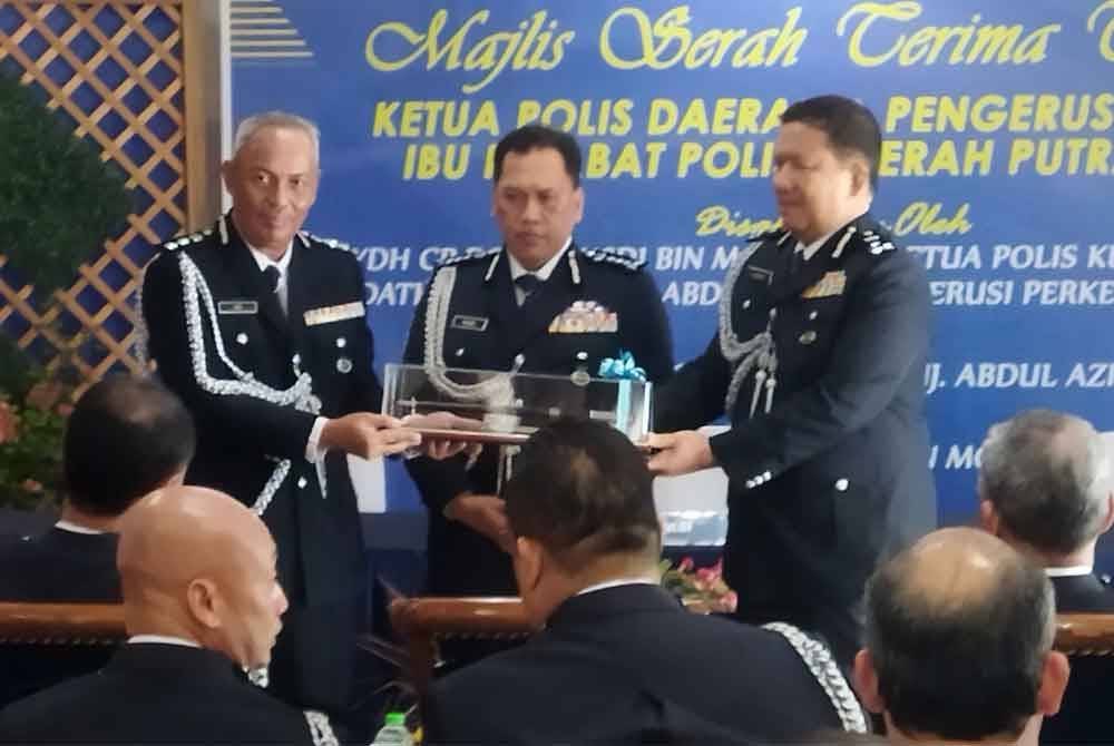 A Asmadi (kanan) menyerahkan tongkat kuasa kepada Aidi Sham (kiri) pada Majlis Serah Terima Tugas di Ibu Pejabat Polis Daerah (IPD) Putrajaya pada Khamis.