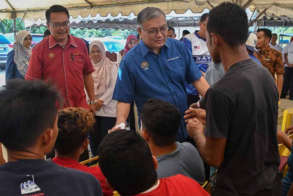 Shamsul Anuar (dua dari kanan) beramah mesra bersama sebahagian klien pada Program Bersama Klien dan Keluarga Agensi Antidadah Kebangsaan (AADK) Daerah Gua Musang di Kampung Pulau Setelu hari ini. Foto Bernama