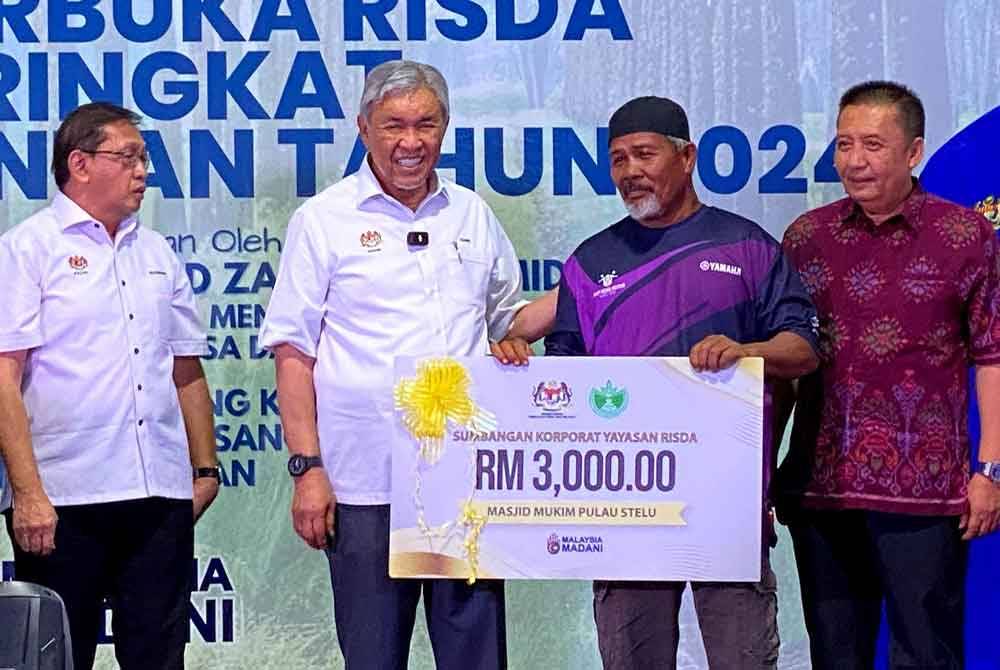 Ahmad Jazlan (kanan) bersama Ahmad Zahid (dua, kiri) semasa Program Hari Terbuka Risda Peringkat Negeri Kelantan Tahun 2024 di Kampung Kala Star, Gua Musang pada Khamis.