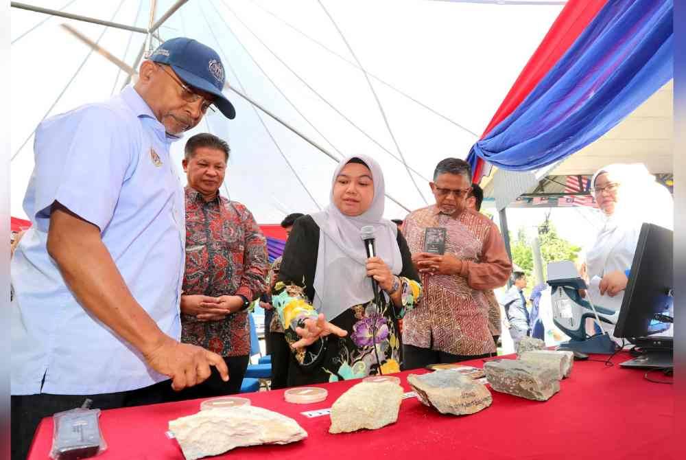 Zambry (kiri) melihat batuan gunung berapi semasa melawat ke UMK Jeli pada Khamis. Foto Ihsan UMK