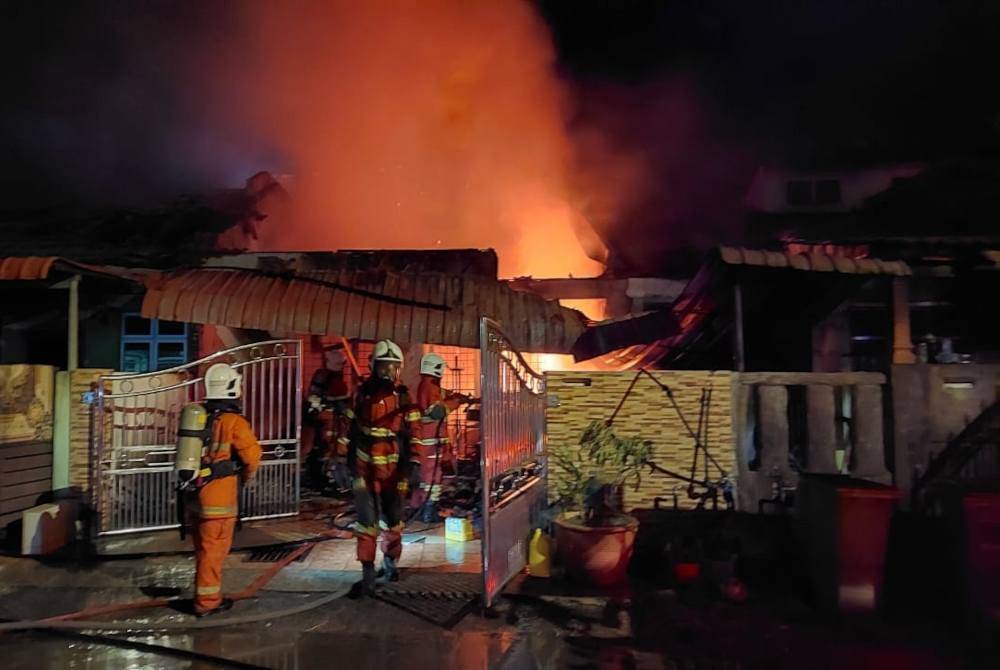 Anggota bomba membantu memadam kebakaran melibatkan tiga rumah teres di Pinggiran Putra 4, Taman Kempadang Makmur di sini pada Khamis malam.