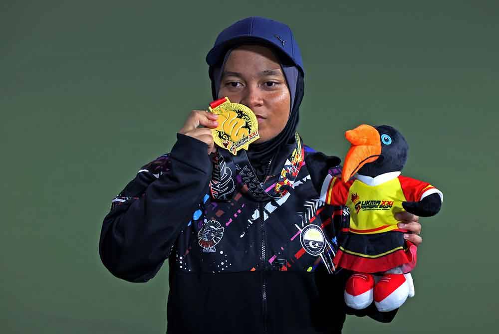 Nur Ain Kemilia memperagakan pingat emas yang dimenangi selepas mengalahkan pemain Selangor pada Sukma Sarawak 2024. Foto Bernama