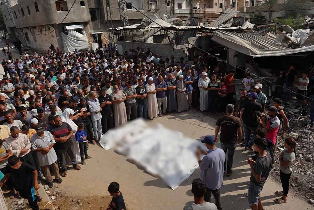 Penduduk Gaza menunaikan solat jenazah keluarga Qadih yang terkorban dalam serangan udara Israel di Bani Suheila. Foto AFP