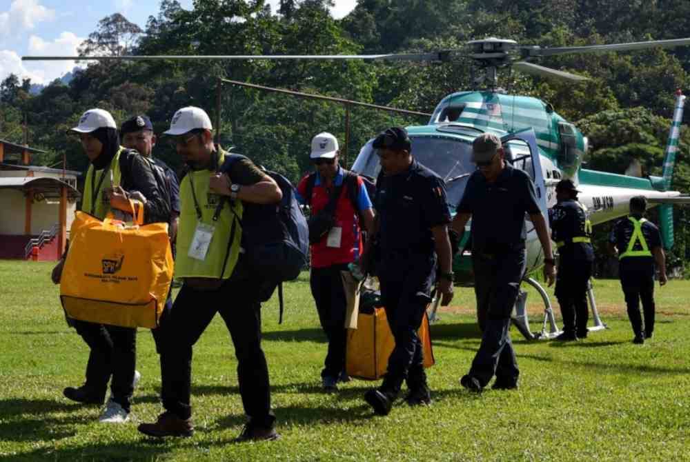 Petugas SPR membawa turun peti-peti undi dari pusat-pusat mengundi Pos Gob dan Pos Simpor sempena PRK Nenggiri sebaik tiba dengan menaiki helikopter di Padang Dewan Perdana, Kompleks Perdana, Majlis Daerah Gua Musang hari ini. Foto Bernama