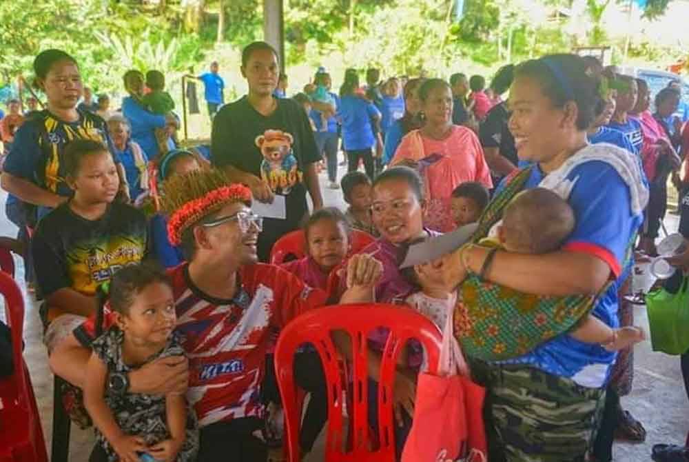 Awie (kiri) bersama masyarakat Orang Asli semasa berkempen sepanjang PRK DUN Nenggiri.