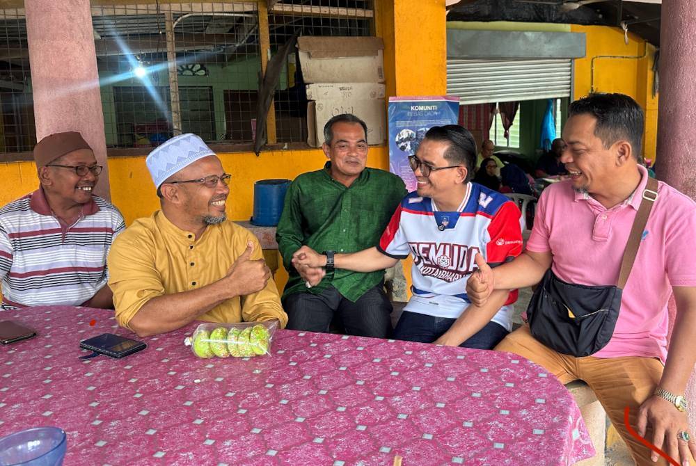 Mohd Azmawi (dua dari kanan) yang beramah mesra dengan penduduk di Sungai Asap A di Gua Musang pada Ahad.