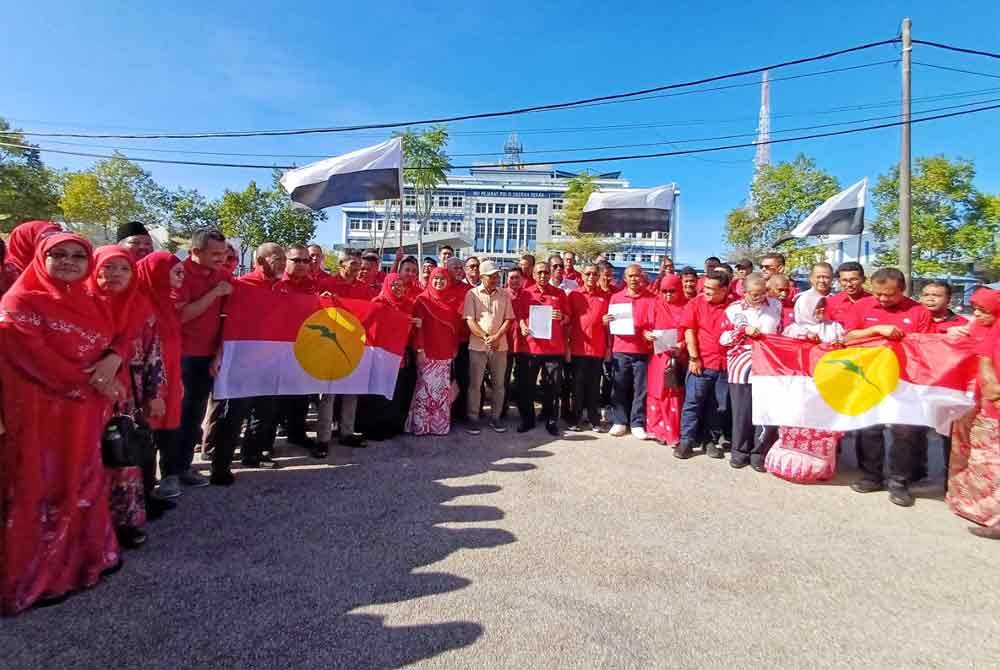 Mohammad Fakhruddin bersama 100 ahli UMNO Pekan selepas satu laporan polis dibuat wakil UMNO Pekan di Ibu Pejabat Polis Daerah Pekan pada Ahad.