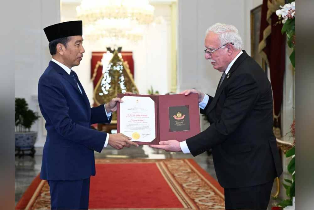 Jokowi (kiri) menerima penghargaan tertinggi dari pemerintah Palestina, “Grand Collar Order of the State of Palestine” di Istana Merdeka, Jakarta pada Isnin.