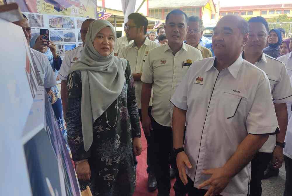 Fadhlina (kiri) melihat pelan pembangunan baik pulih sekolah yang telah disiapkan pada Majlis Penyerahan Projek KPM di SMK Bagan Terap di sini pada Isnin.