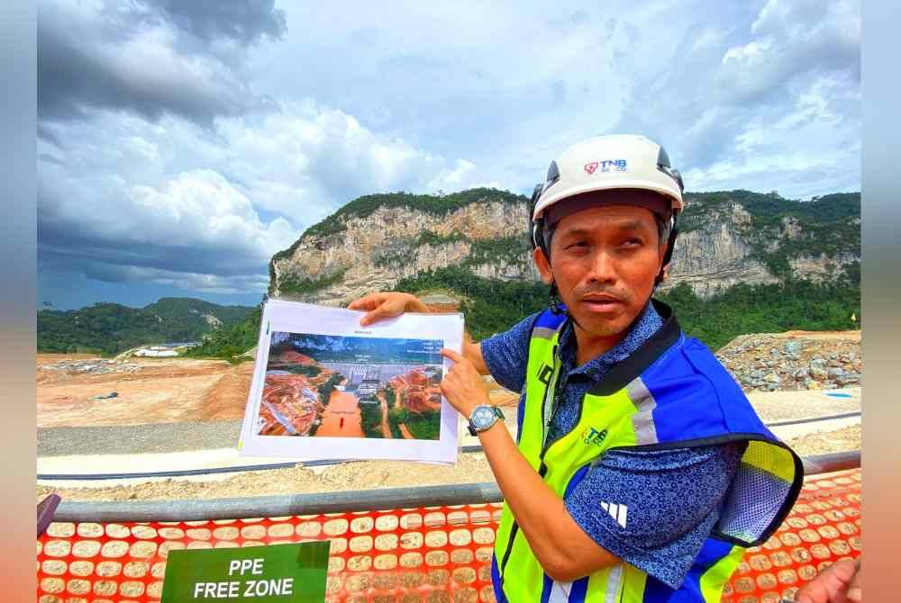 Muhamad Nazri menunjukkan perkembang terkini Empangan Nenggiri semasa Lawatan Media ke Tapak Projek Hidroelektrik Nenggiri, Gua Musang.