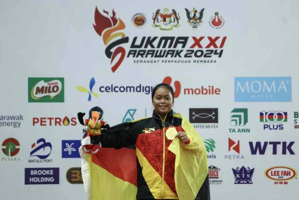 Pauline menunjukkan pingat emas yang dimenangi dalam acara lempar cakera pada Sukma Sarawak 2024. Foto Bernama