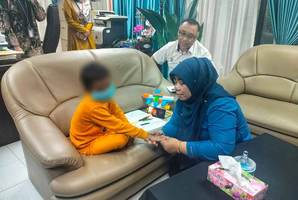 Halimaton Shaadiah (kanan) bermesra dengan kanak-kanak lelaki berkenaan di Pejabat JKM Kedah pada Rabu.