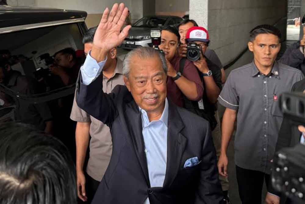 Muhyiddin melambai tangan kepada pemberita selepas selesai memberikan keterangan kepada pihak polis pada Rabu.