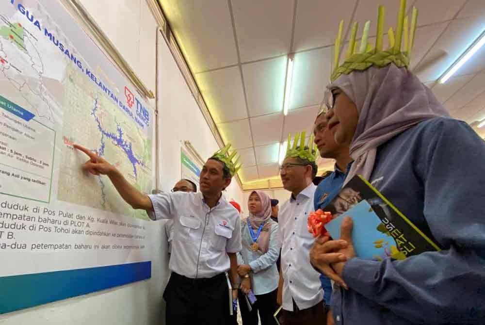 Muhamad Nazri (kiri) memberi penerangan pada Majlis Penghargaan dan Kerjasama Strategik Bersama Orang Asli Pos Tohoi dan Pulat di Gua Musang pada Rabu.