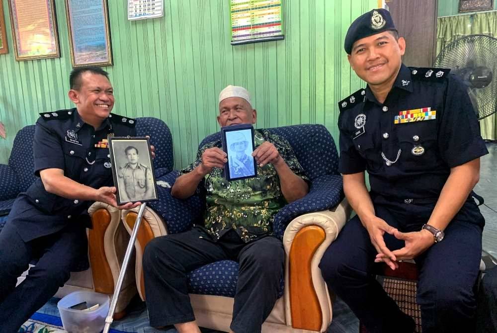 Hussin (tengah) ditemani anaknya Ahmad Shafiki (kiri) bergambar kenangan bersama Ketua Polis Daerah Bachok pada Program Santuni Pesara Polis Sempena Bulan Kemerdekaan IPD Bachok di Kampung Alor Bakat pada Khamis. Foto Bernama