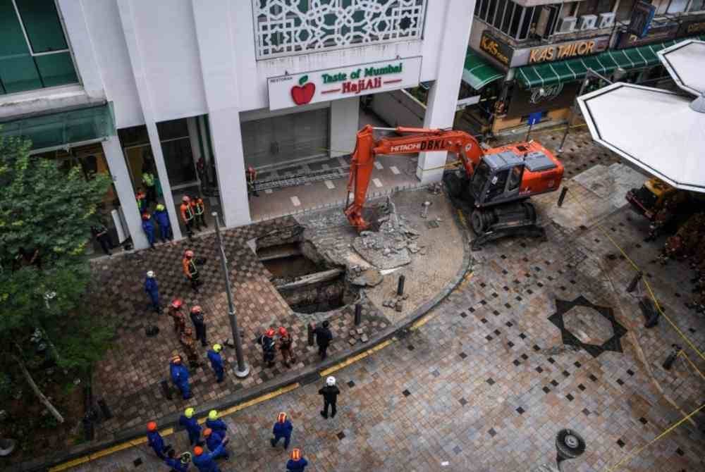 Anggota Jabatan Bomba dan Penyelamat Malaysia serta Angkatan Pertahanan Awam Malaysia kini giat menjalankan kerja-kerja mengeluarkan mangsa yang merupakan seorang pelancong. Foto Bernama