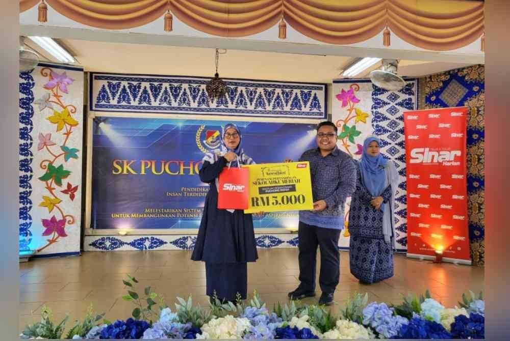 
Zamri (kanan) menyampaikan replika hadiah wang tunai RM5,000 yang dimenangi SK Puchong Indah, kepada Nik Suhaida pada Jumaat.