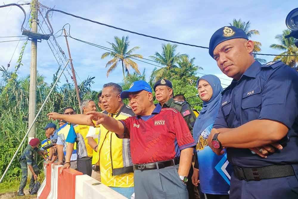 Saarani (dua dari kanan) ketika meninjau keadaan runtuhan jambatan di Jalan Slim River-Behrang Ulu pada Sabtu.