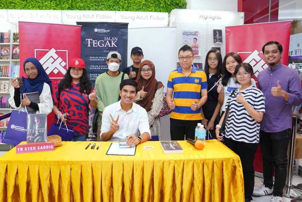 Syed Saddiq (duduk) bersama antara peminat yang hadir semasa sesi temu mesra pada Sabtu