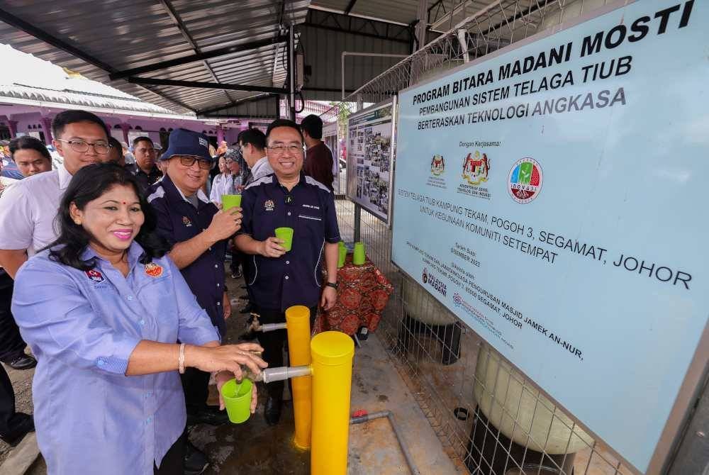 Lih Kang (kanan) mencuba air daripada Telaga Tiub Berteraskan Teknologi Angkasa pada Majlis Peluncuran Kampung Angkat Madani MOSTI 2024, di Masjid Jamek Kampung Tekam Pogoh 3, pada Sabtu. Foto Bernama