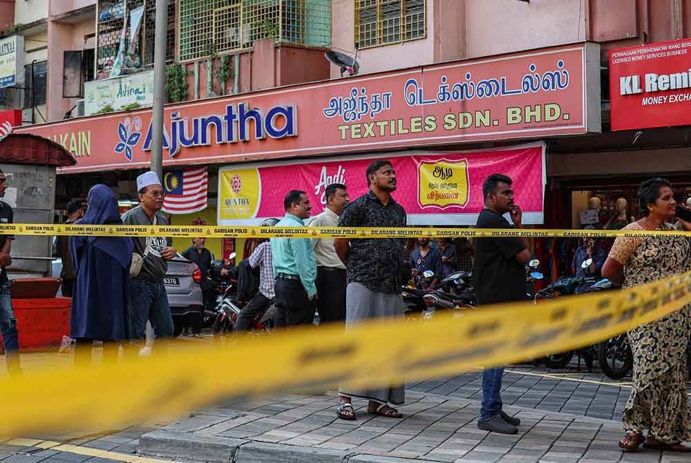 Orang ramai melihat keadaan terkini di sekitar operasi pencarian warga India yang menjadi mangsa insiden tanah jerlus di Jalan Masjid India pada Sabtu. Foto Bernama