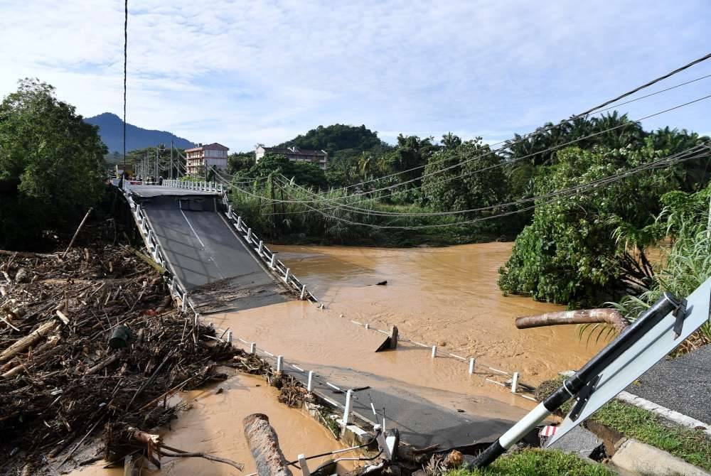 Keadaan jambatan lama Sungai Slim yang runtuh akibat kejadian kepala air petang semalam ketika tinjauan pada Sabtu. Foto Bernama