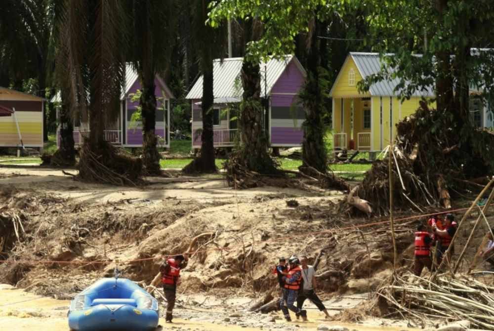 Anggota Jabatan Bomba dan Penyelamat (JBPM) bersama Angkatan Pertahanan Awam (APM) membawa keluar 21 mangsa yang terkandas di Tapak Perkemahan Eco Risda, Kampung Ulu Slim dalam insiden kepala air ekoran empangan pecah di Slim River. Foto Bernama