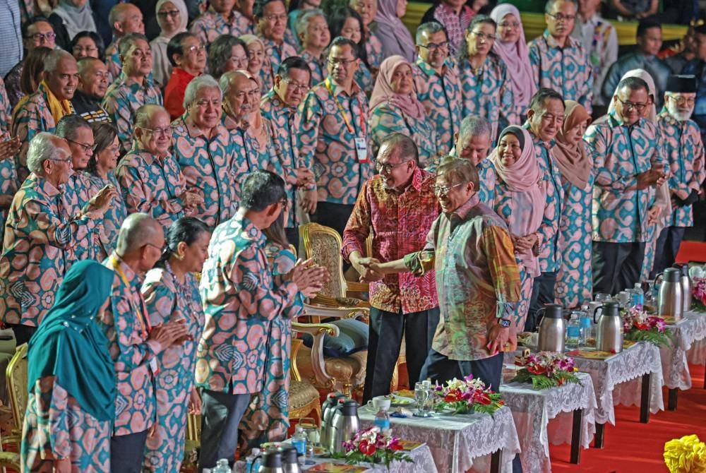 Anwar bersalaman dengan Premier Sarawak, Tan Sri Abang Johari Tun Openg semasa Majlis Penutup Sukan Malaysia (Sukma) Sarawak 2024 di Stadium Perpaduan Petra Jaya pada Sabtu. Foto Bernama