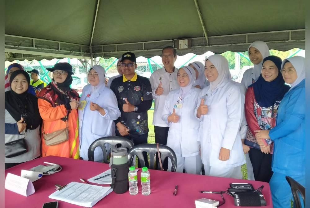 Mohammad Nizar (lima dari kiri) bersama warga Kementerian Kesihatan yang menyediakan khidmat pemeriksaan kesihatan percuma sempena Program Jelajah Sejahtera Desaku DUN Sungai Rapat di padang Taman Lapangan Jaya, Kampung Rapat pada Ahad.